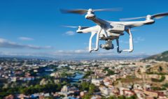 drone with digital camera flying or hovering in blue sky over the city